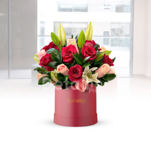 Caja guinda de flores variadas con rosas lirios y follajes